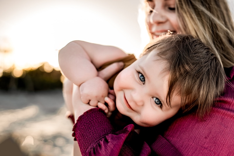 Family Photographer, a mother holds her smiling son in her arms
